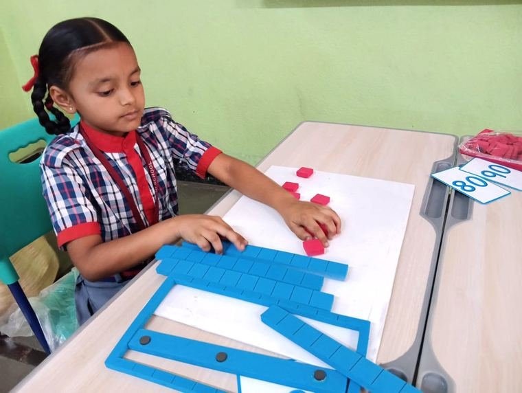 Primary student learning place value with maths blocks